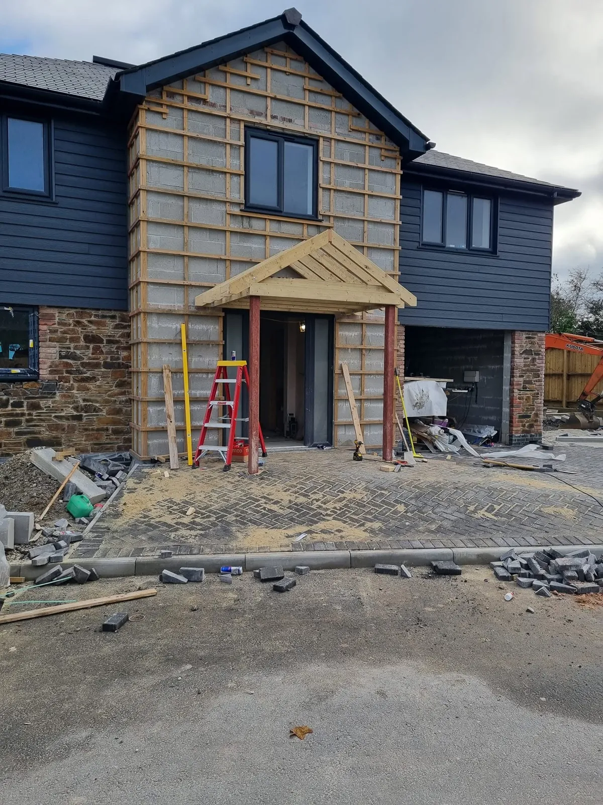 New house being clad, with a timber porch